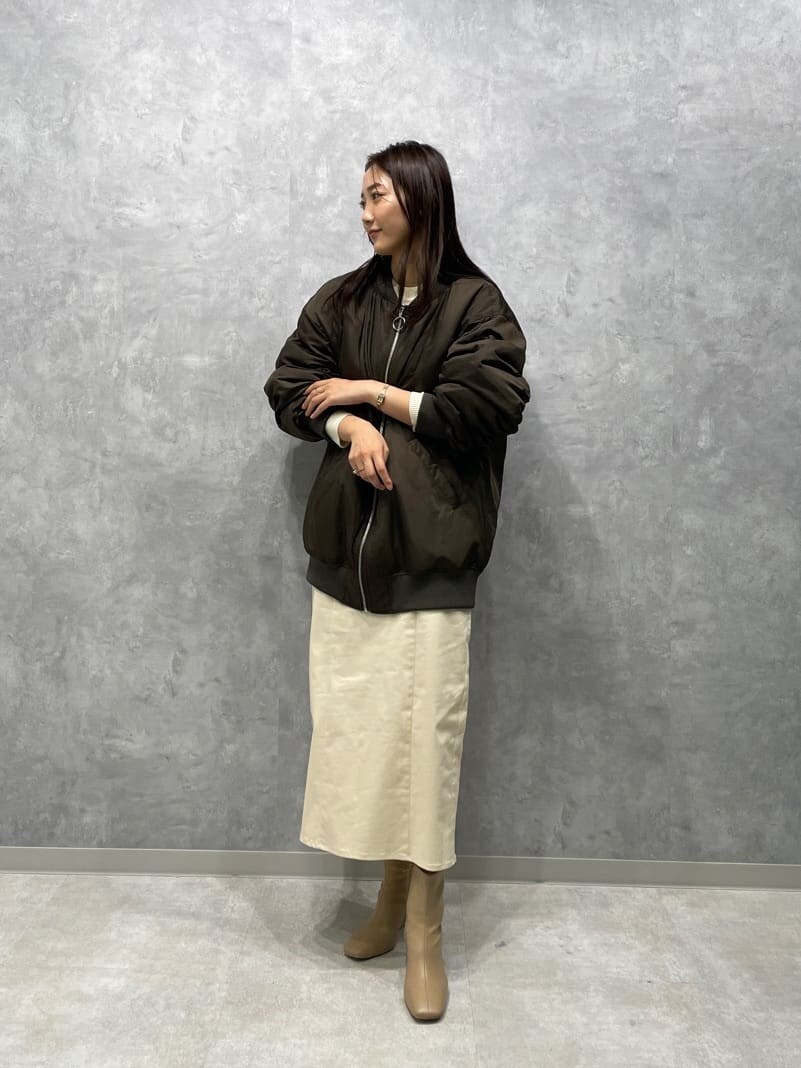 ベージュ系のブーツ、ホワイト系のニット/セーター、ブラウン系のMA-1を着用したレディースの秋コーディネートの5枚目の写真