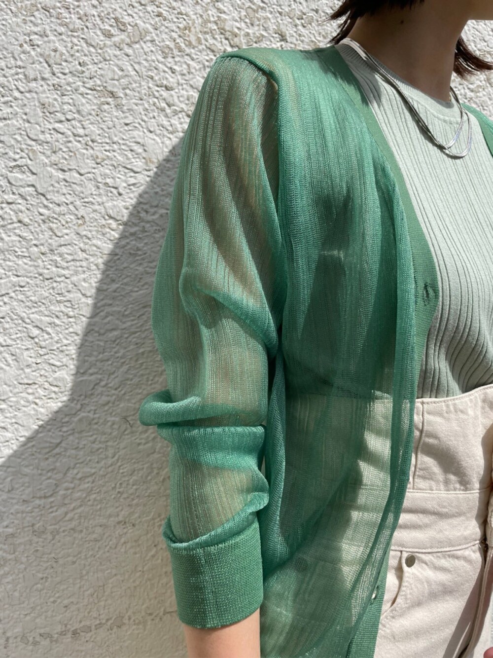 その他のパンプス、ホワイト系のデニムパンツ、グリーン系のニット/セーターを着用したレディースの春コーディネートの3枚目の写真