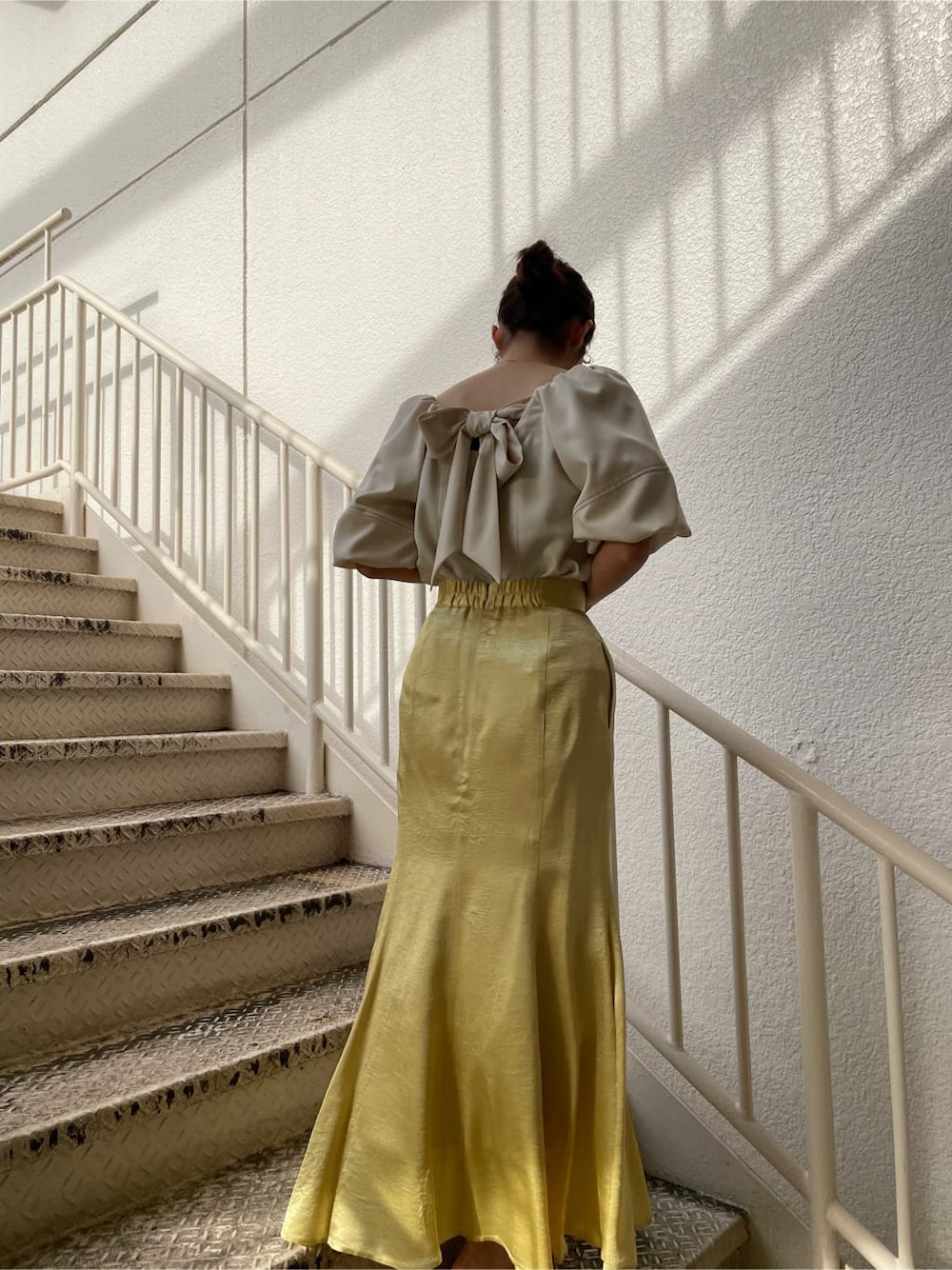 ホワイト系のシャツ/ブラウス、ホワイト系のテーラードジャケット、イエロー系のスカートを着用したレディースの冬コーディネートの6枚目の写真