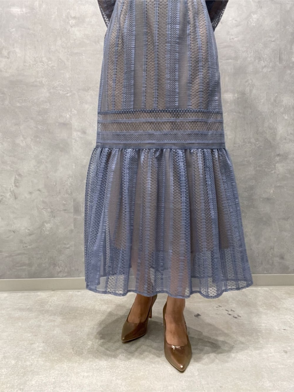 ゴールド系のパンプス、ゴールド系のクラッチバッグ、ブルー系のドレスを着用したレディースの夏コーディネートの10枚目の写真