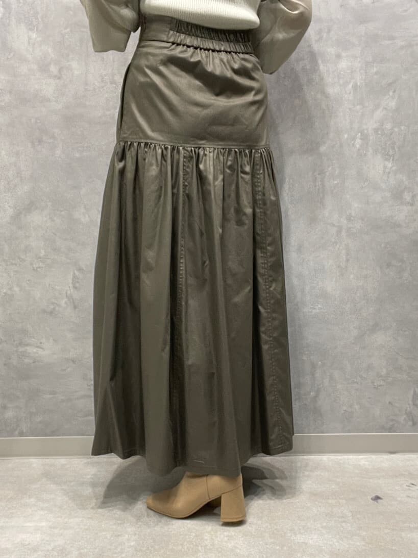 ベージュ系のスカート、ベージュ系のブーツ、グリーン系のニット/セーターを着用したレディースの夏コーディネートの10枚目の写真