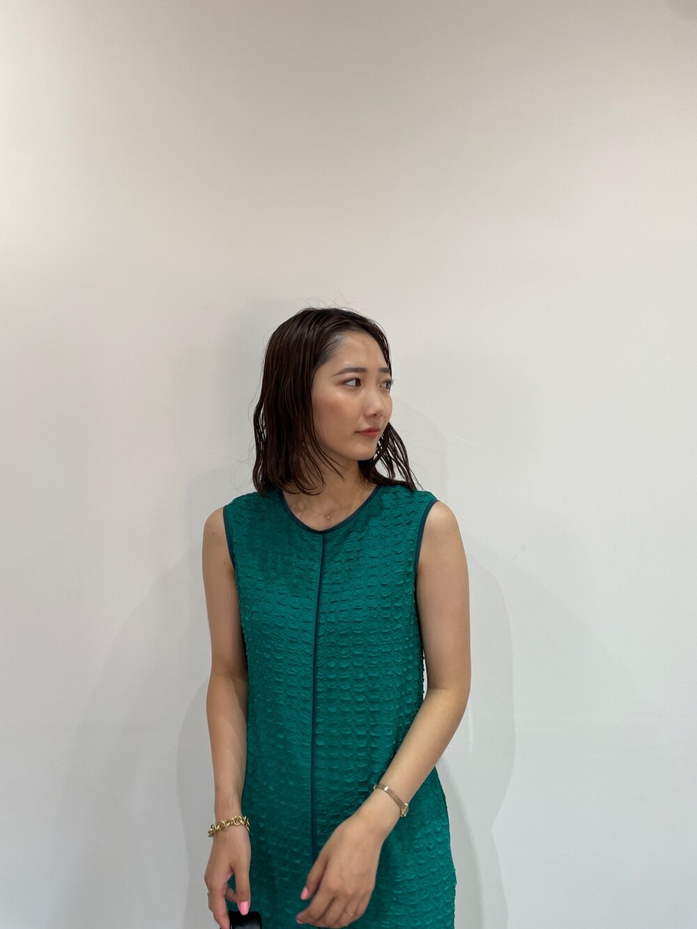 グリーン系のワンピース、ブラック系のサンダル、ブラック系のハンドバッグを着用したレディースの夏コーディネートの7枚目の写真