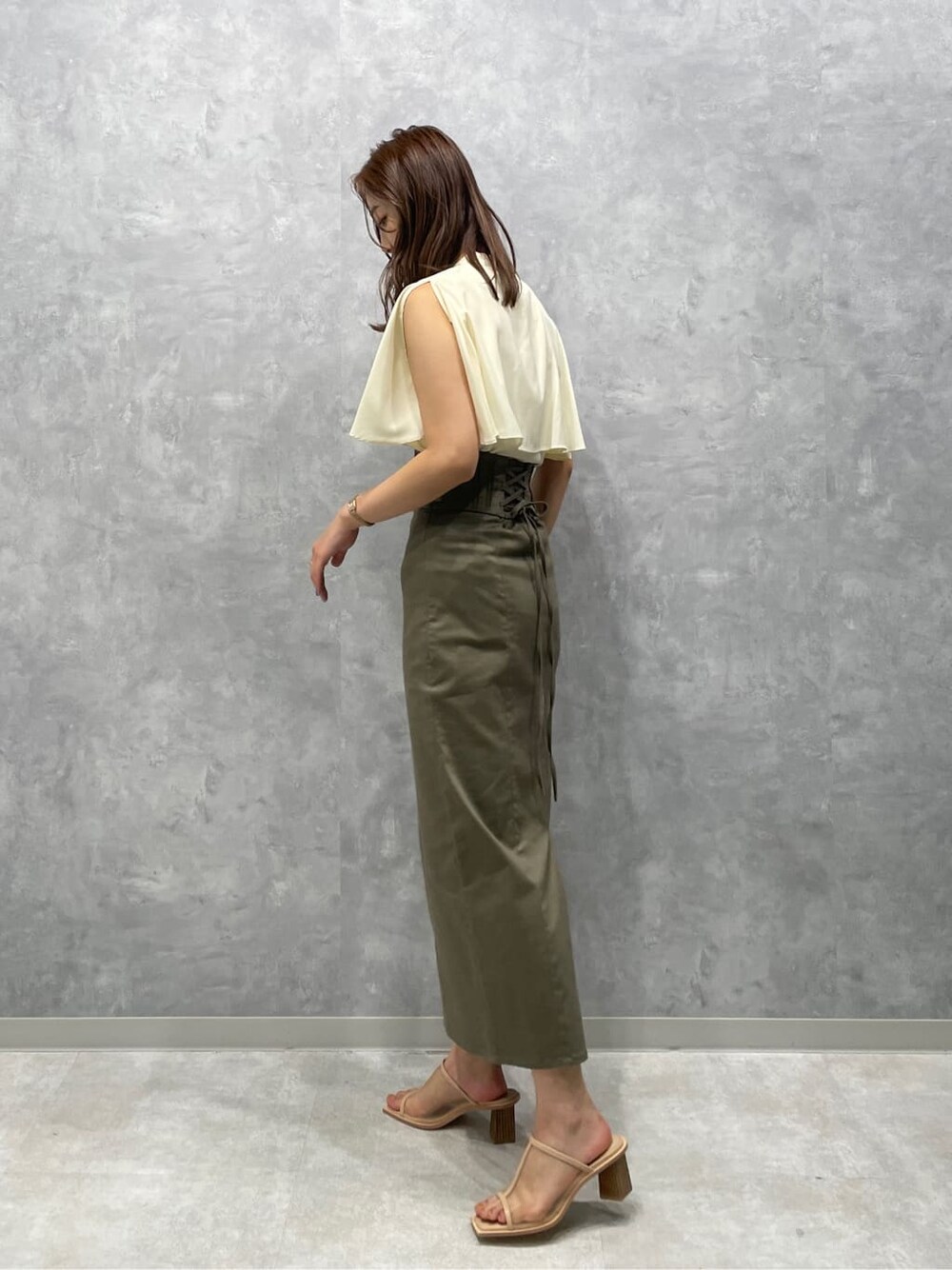 ベージュ系のスカート、ベージュ系のサンダル、ホワイト系のシャツ/ブラウスを着用したレディースの夏コーディネートの4枚目の写真