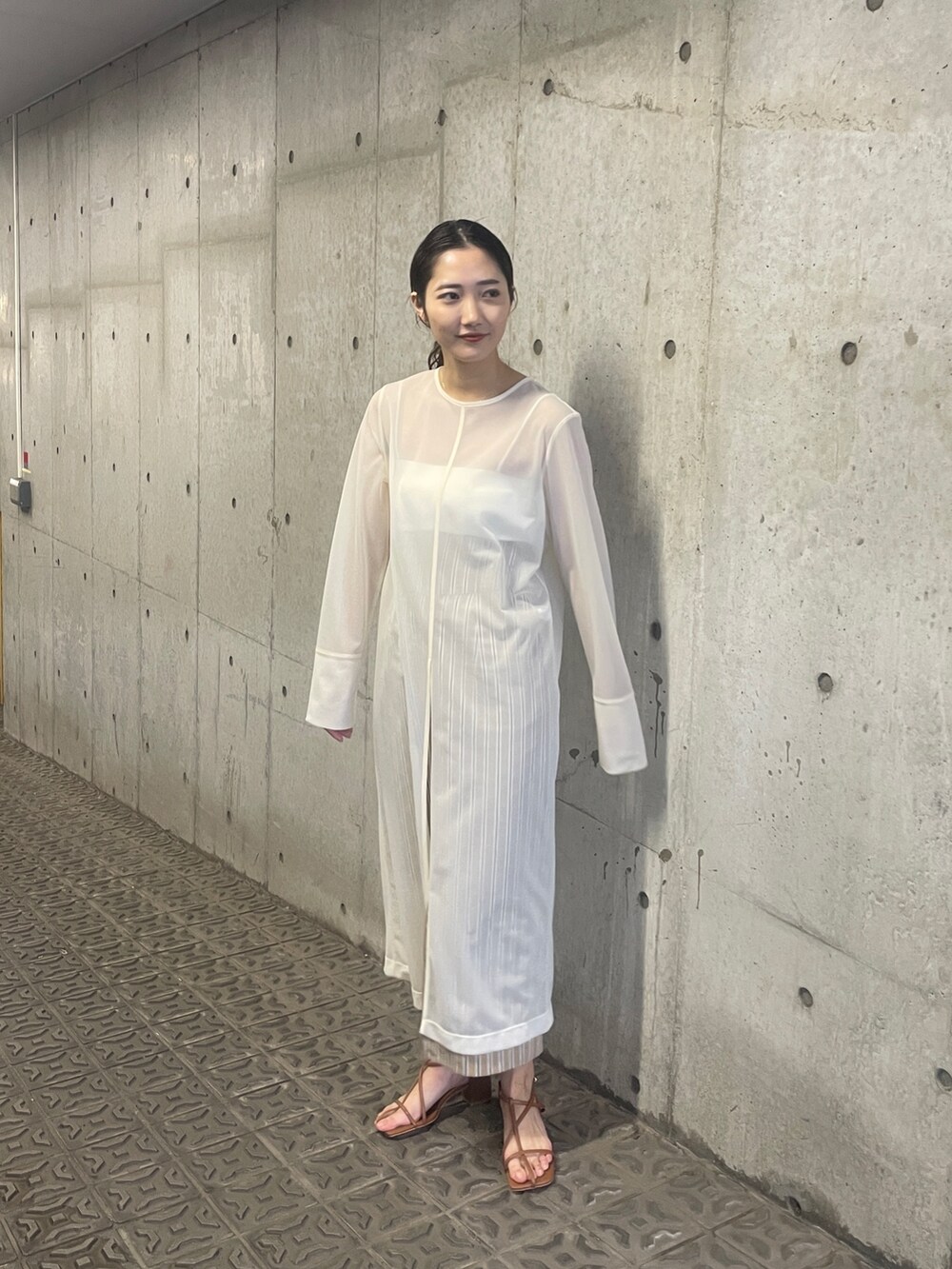 ホワイト系のTシャツ/カットソー、ベージュ系のスカート、ブラウン系のサンダルを着用したレディースの春コーディネートの3枚目の写真