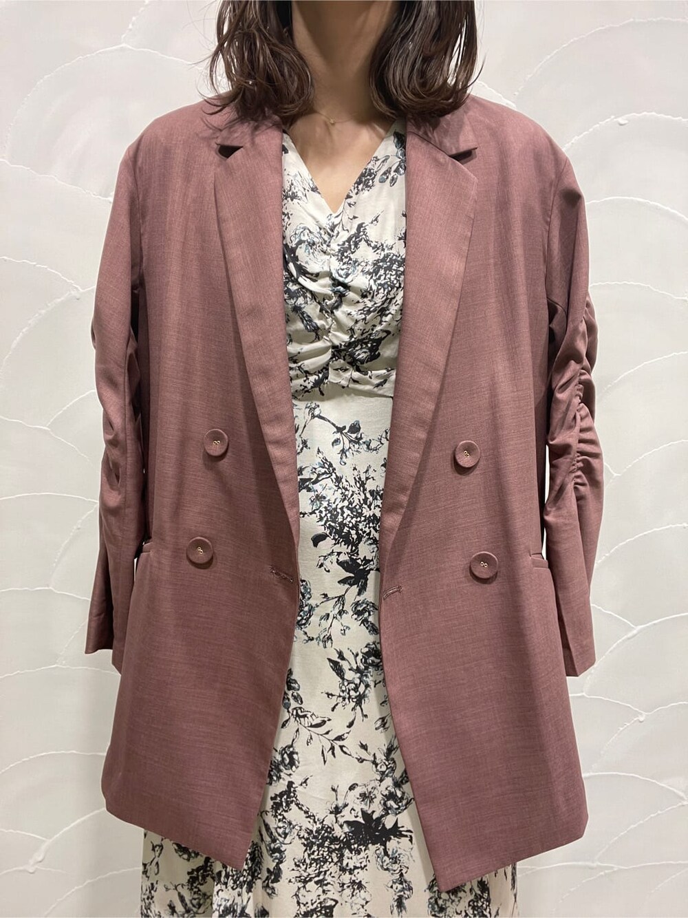 パープル系のテーラードジャケット、ベージュ系のブーツ、グレー系のワンピースを着用したレディースの春コーディネートの7枚目の写真