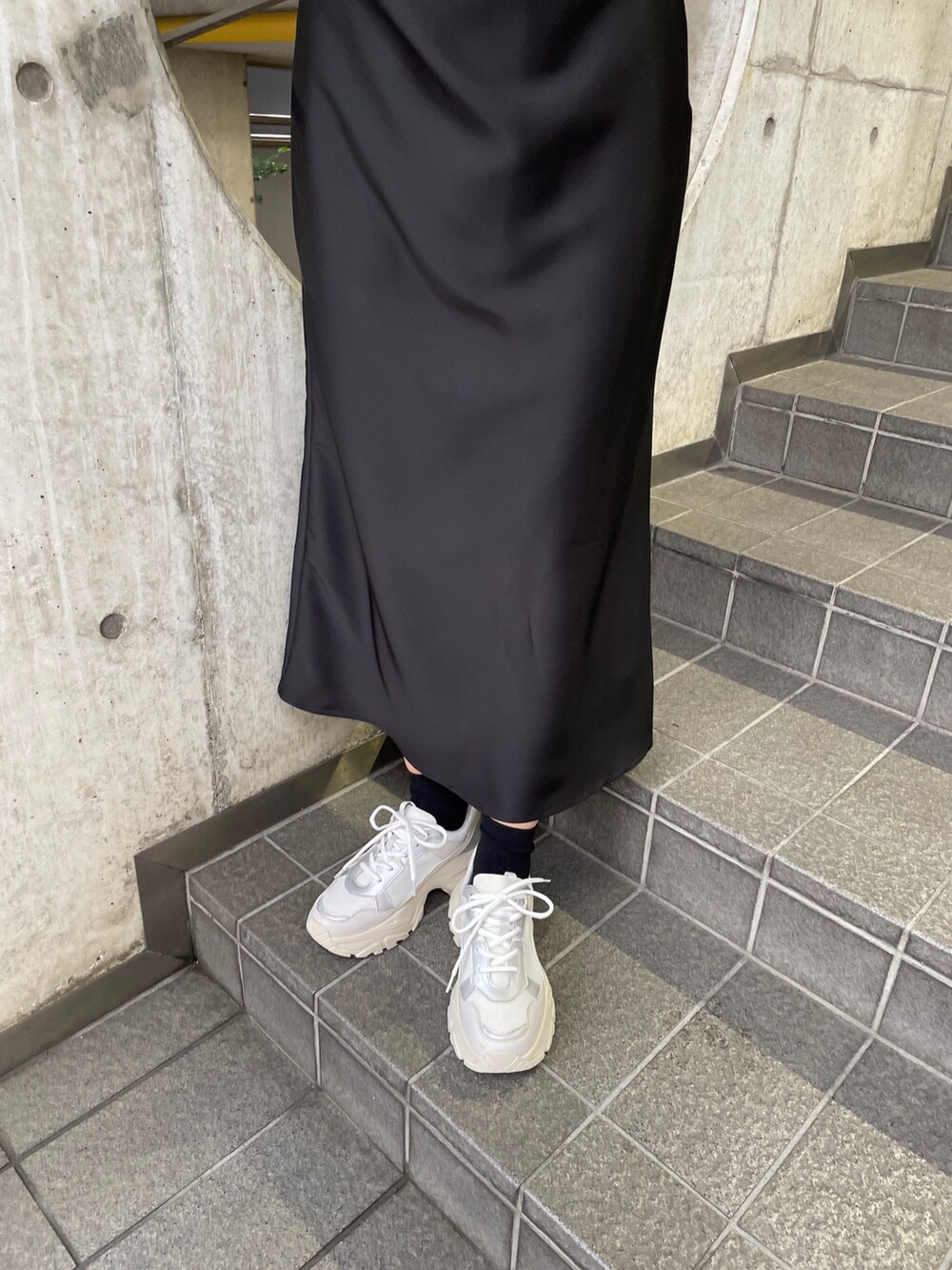 ホワイト系のスニーカー、ブラック系のワンピースを着用したレディースの冬コーディネートの10枚目の写真