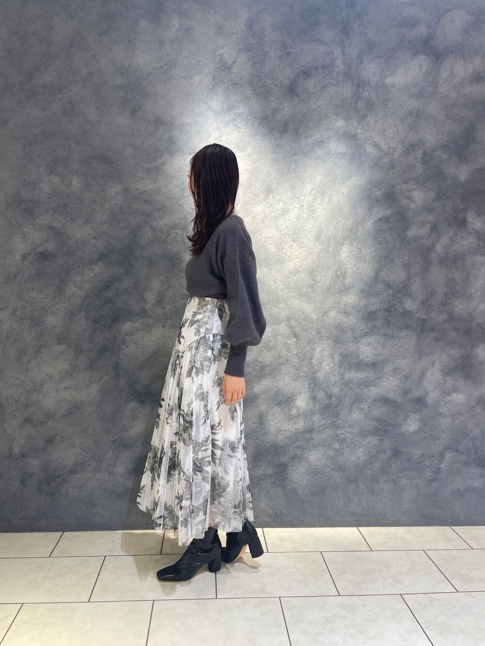 ブラック系のスカート、ブラック系のブーツ、グレー系のニット/セーターを着用したレディースの秋コーディネートの7枚目の写真