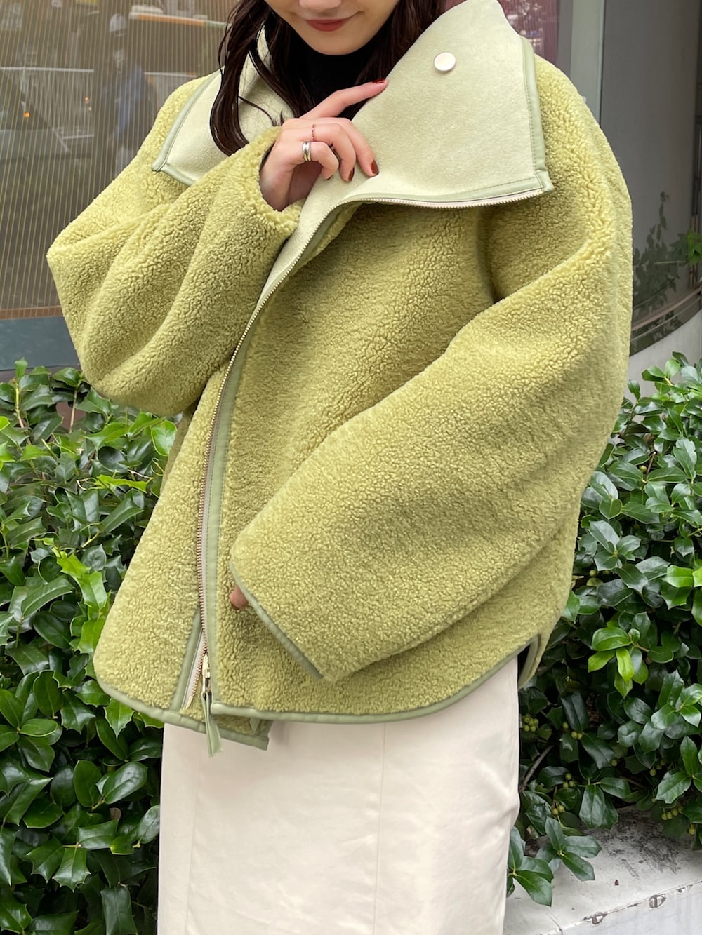 ベージュ系のブーツ、ブラック系のニット/セーター、ホワイト系のスカートを着用したレディースの秋コーディネートの7枚目の写真