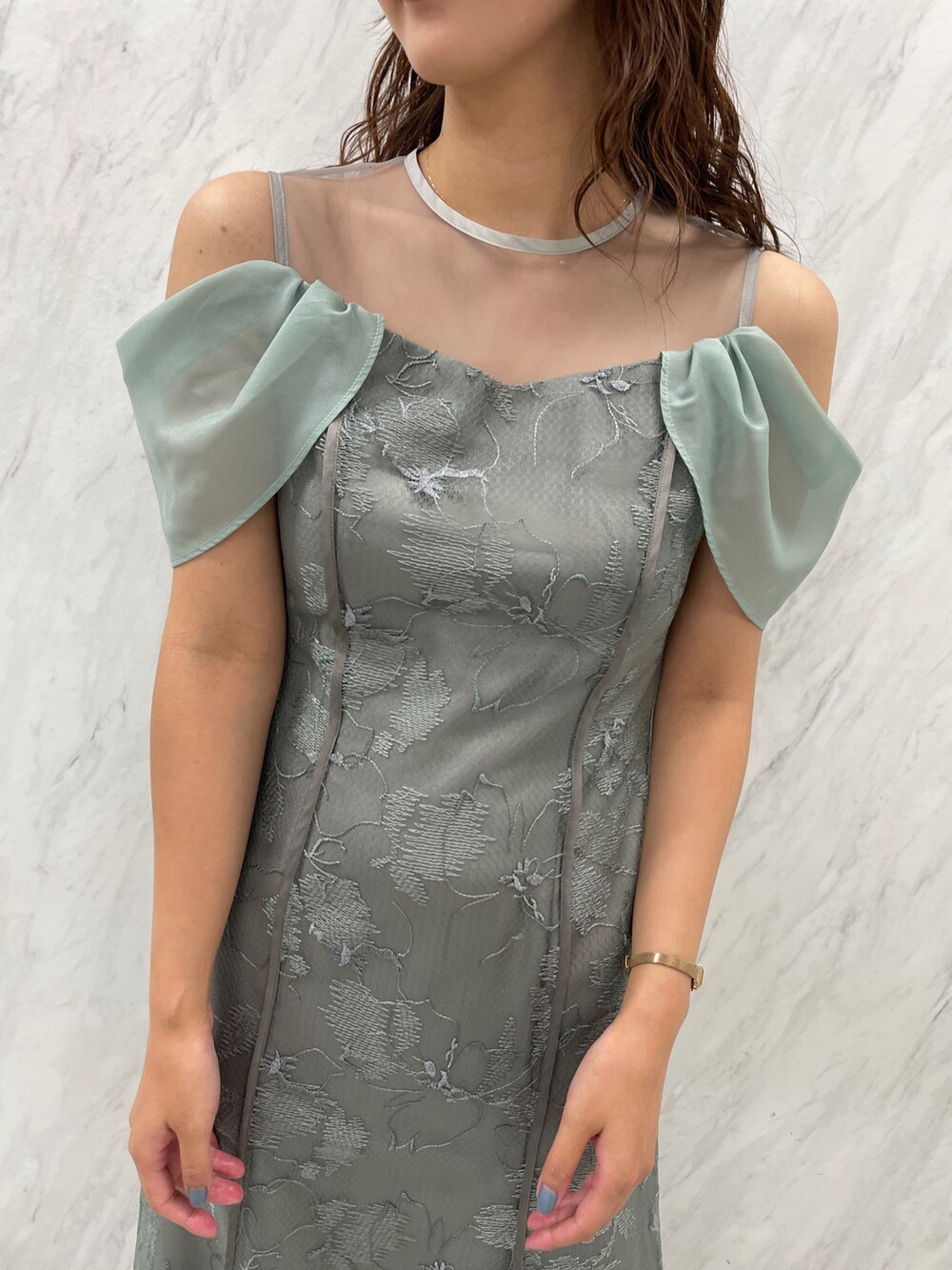 ホワイト系のパンプス、グリーン系のドレスを着用したレディースの冬コーディネートの6枚目の写真