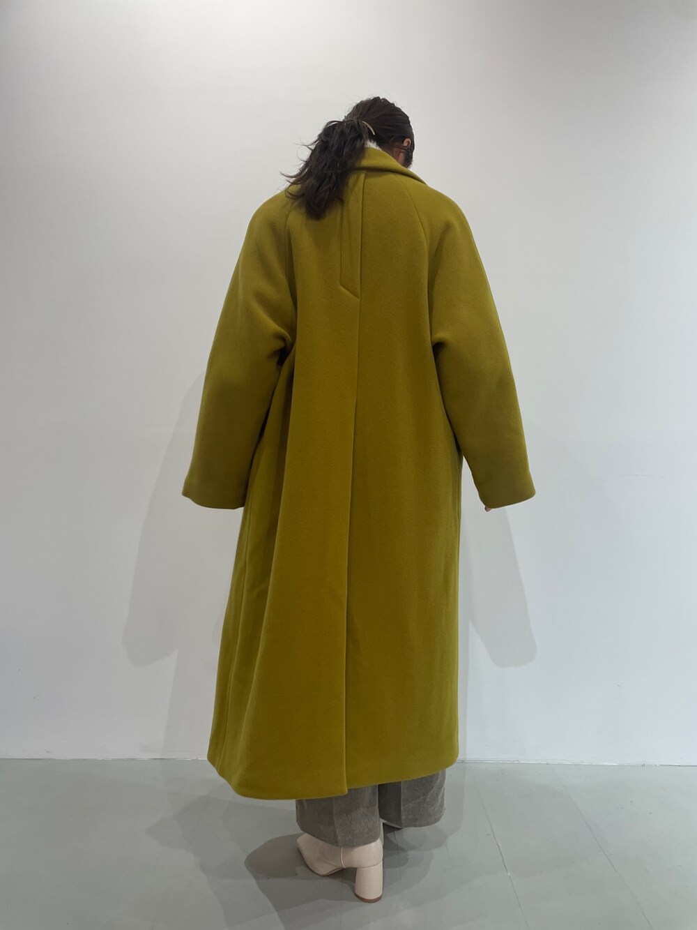 ホワイト系のニット/セーター、ベージュ系のその他パンツ、ホワイト系のブーツを着用したレディースの夏コーディネートの6枚目の写真