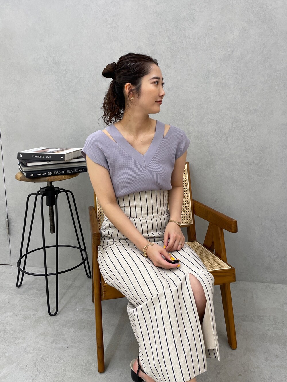 グレー系のスカート、ホワイト系のテーラードジャケット、ブルー系のニット/セーターを着用したレディースの春コーディネートの7枚目の写真