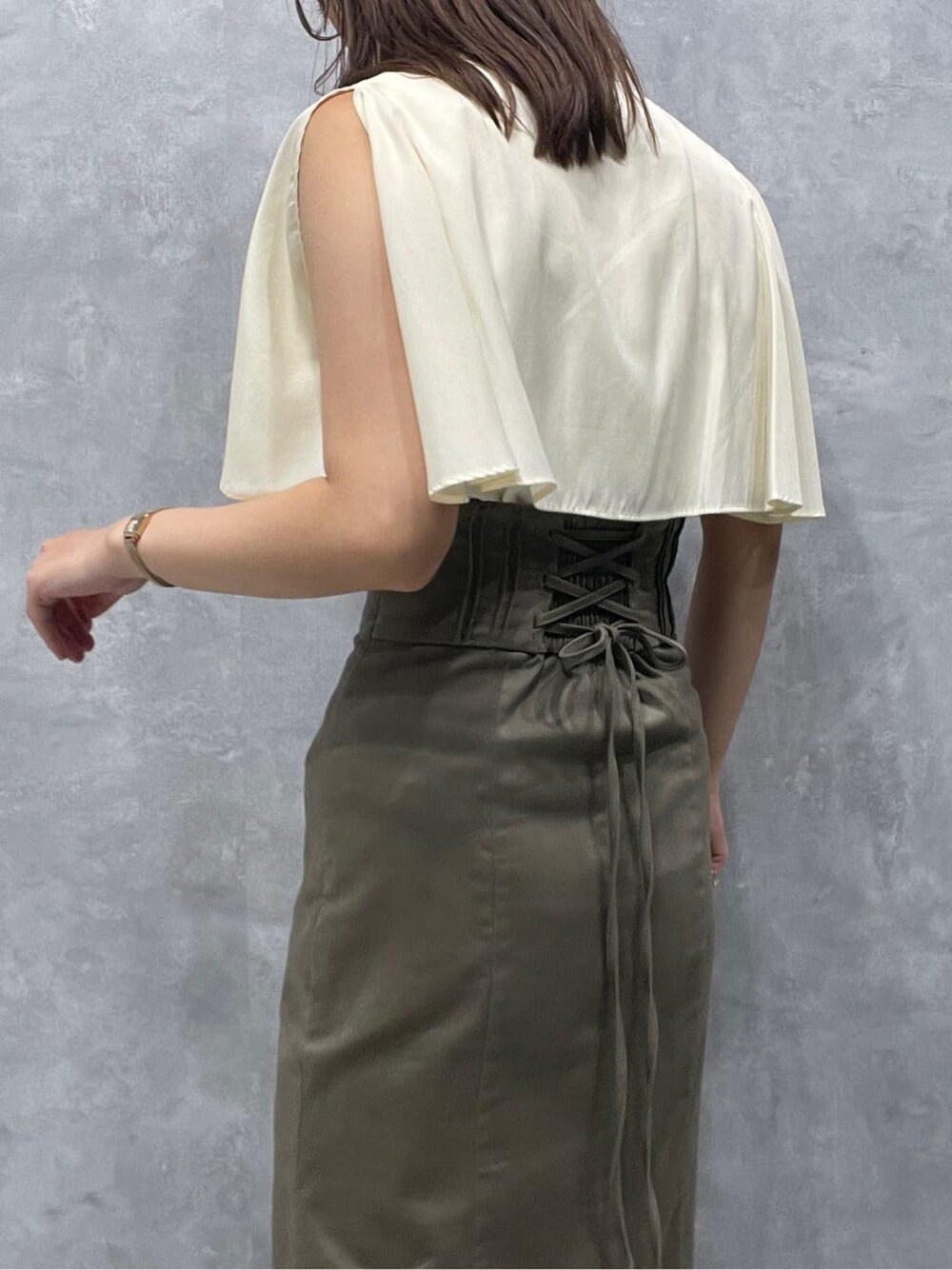 ベージュ系のスカート、ベージュ系のサンダル、ホワイト系のシャツ/ブラウスを着用したレディースの夏コーディネートの7枚目の写真