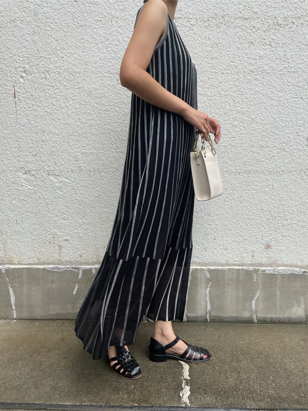 ブラック系のワンピース、ホワイト系のショルダーバッグを着用したレディースの夏コーディネートの5枚目の写真