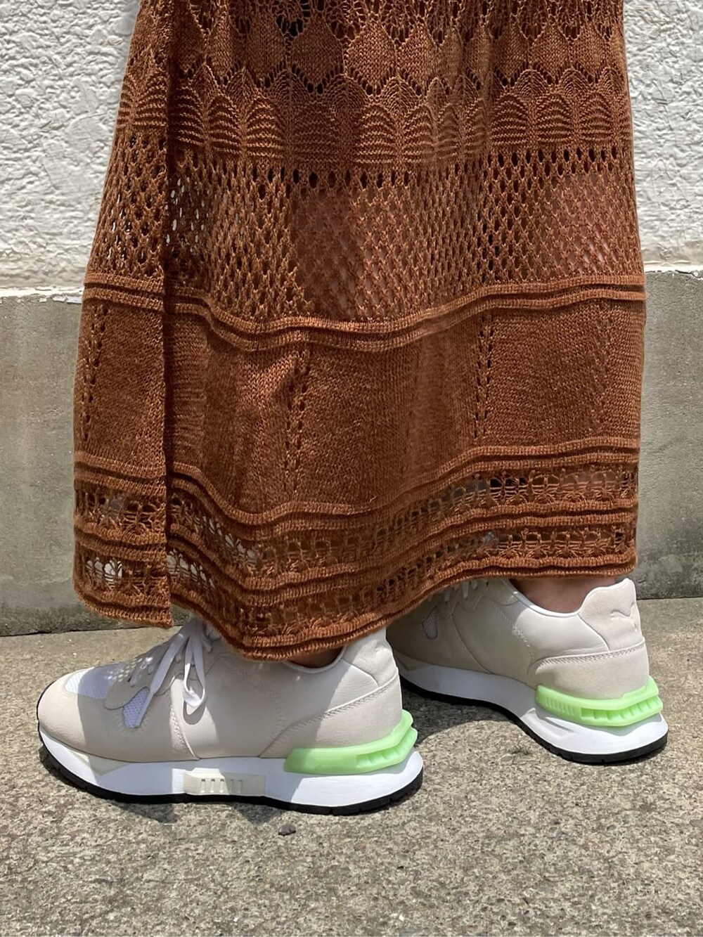 ブラウン系のワンピース、ホワイト系のスニーカー、シルバー系のブレスレットを着用したレディースの夏コーディネートの6枚目の写真