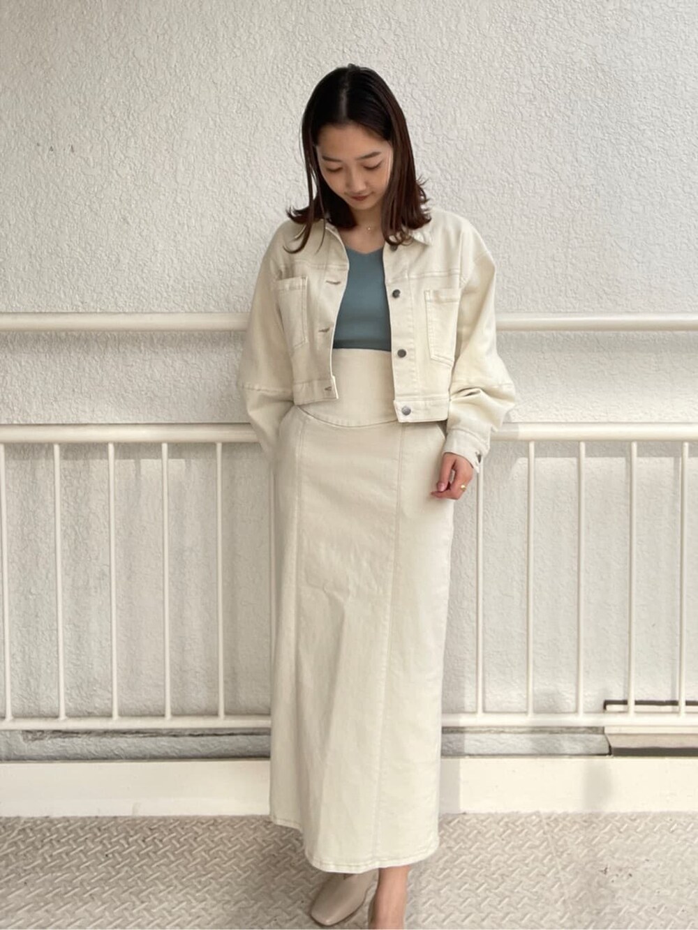 ホワイト系のブルゾン、ホワイト系のスカート、ホワイト系のパンプスを着用したレディースの冬コーディネートの4枚目の写真