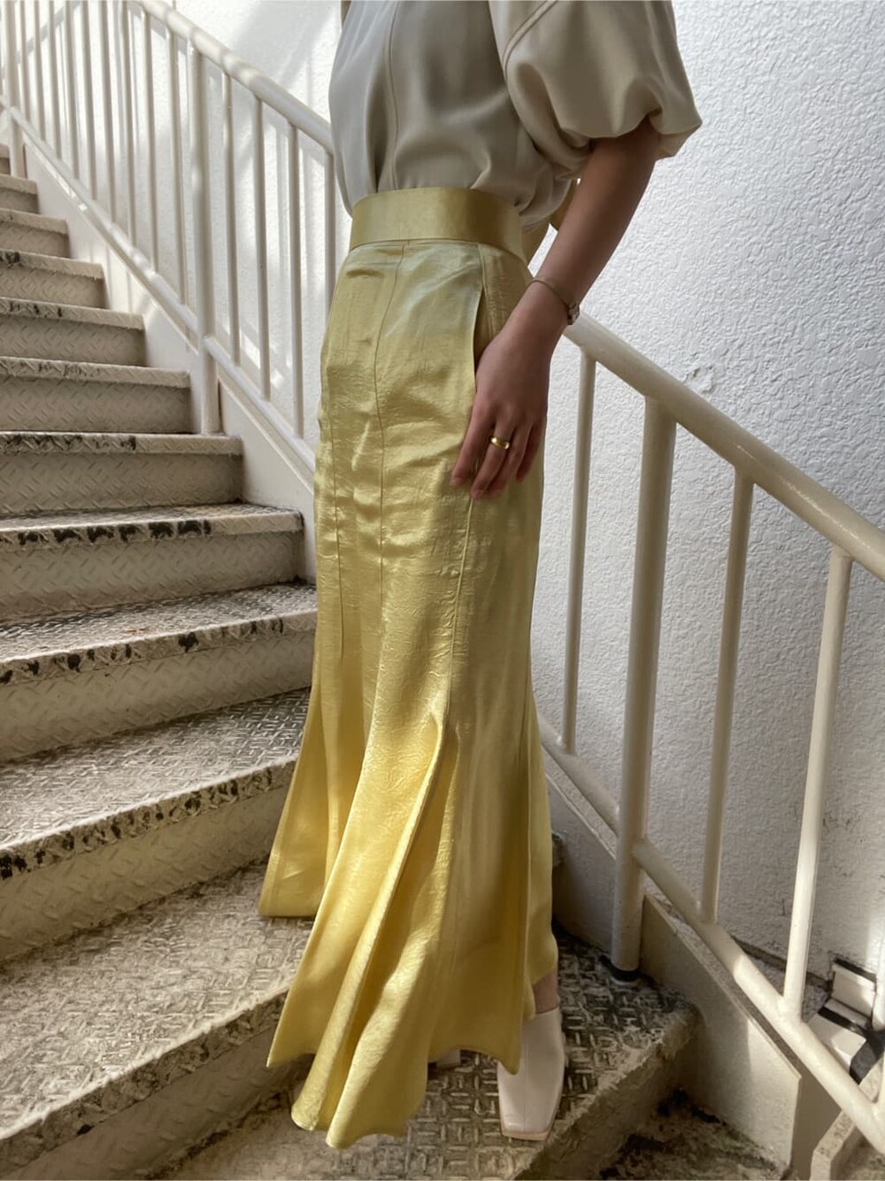 ホワイト系のシャツ/ブラウス、ホワイト系のテーラードジャケット、イエロー系のスカートを着用したレディースの冬コーディネートの10枚目の写真