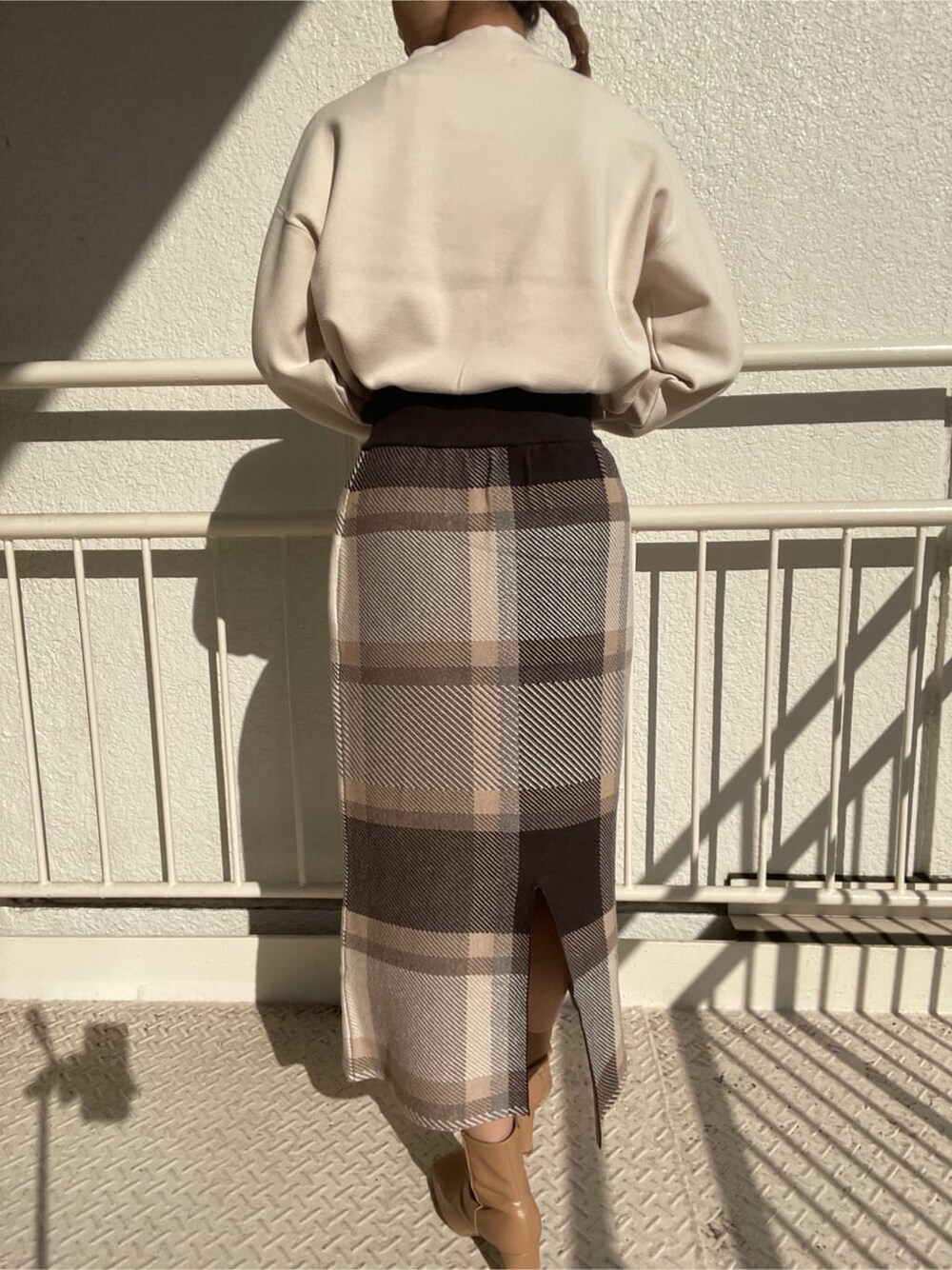 ベージュ系のその他シューズ、グレー系のスカート、ホワイト系のニット/セーターを着用したレディースの冬コーディネートの5枚目の写真