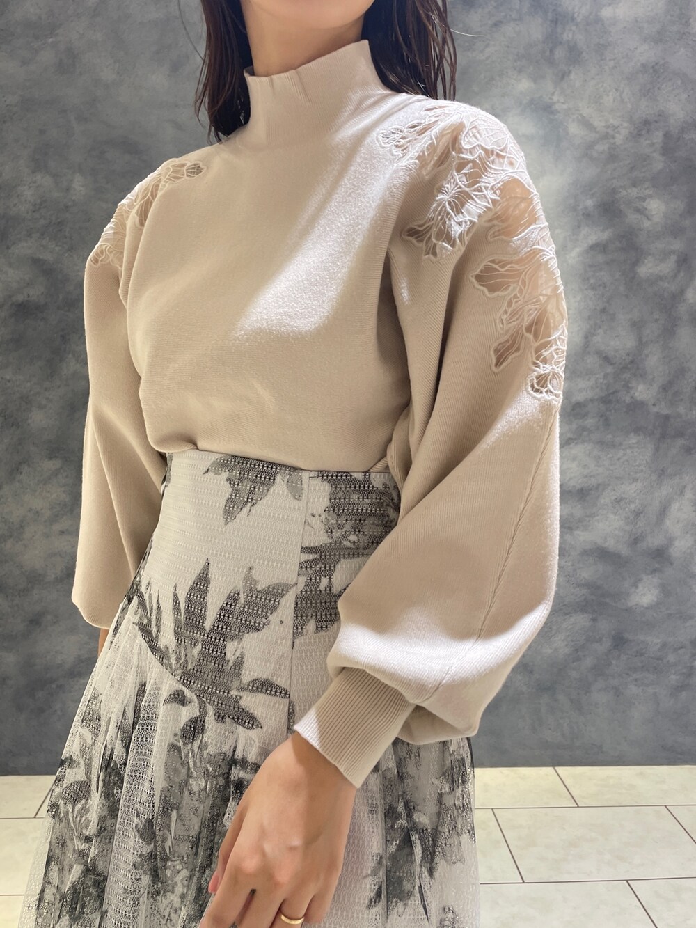 ホワイト系のニット/セーター、ブラック系のブーツ、ブラック系のスカートを着用したレディースの秋コーディネートの7枚目の写真