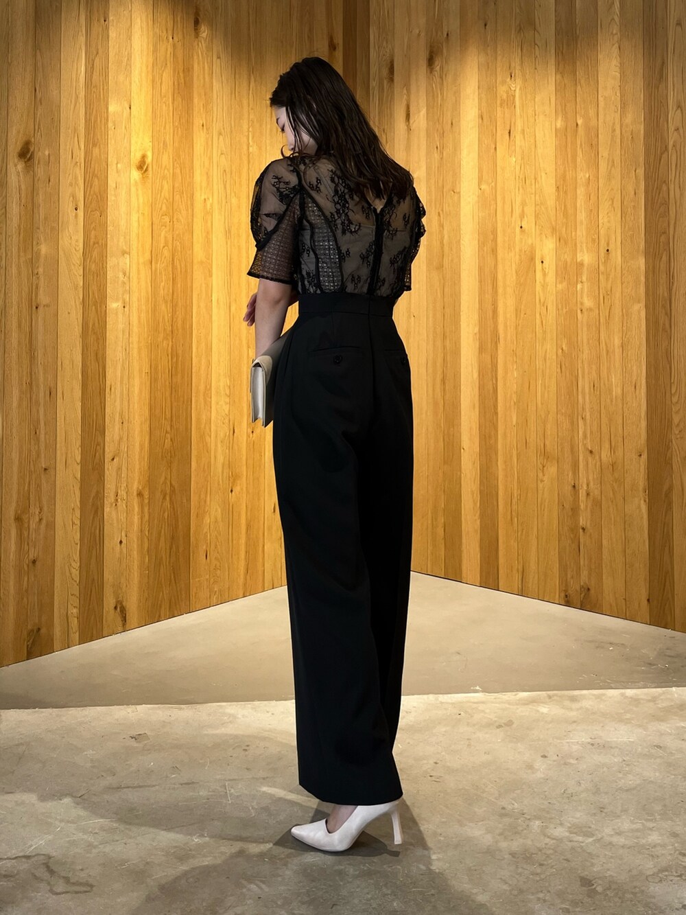 ベージュ系のパンプス、ベージュ系のクラッチバッグ、ブラック系のパンツドレスを着用したレディースの冬コーディネートの4枚目の写真