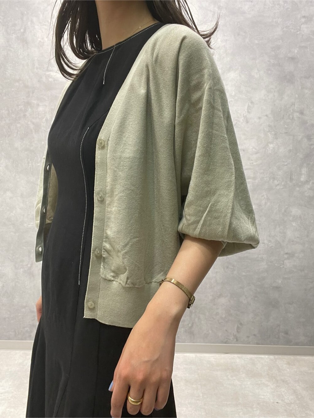 ブラウン系のサンダル、グリーン系のカーディガン/ボレロ、ブラック系のワンピースを着用したレディースの夏コーディネートの4枚目の写真