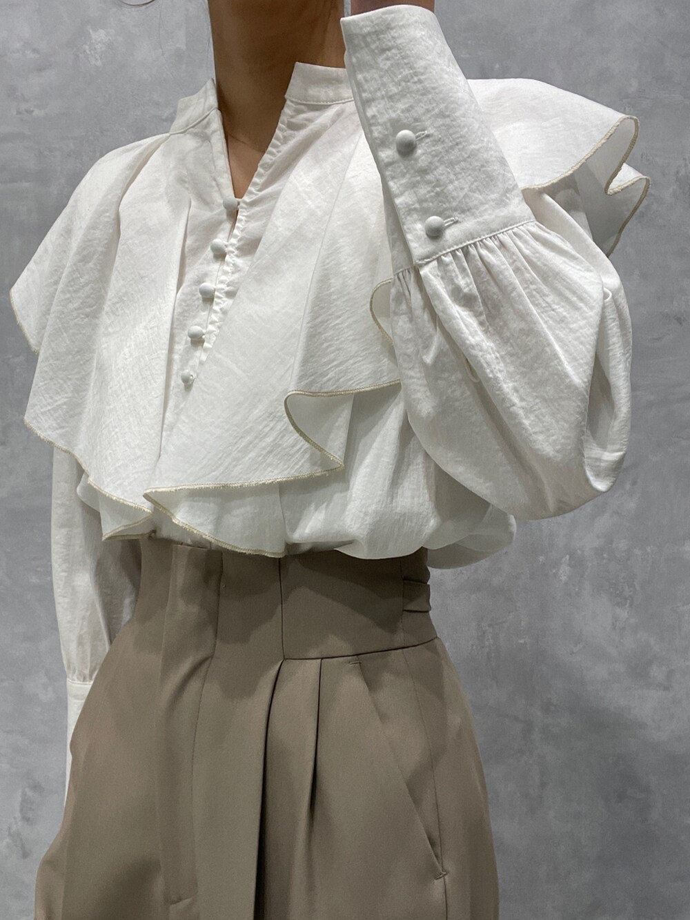 ホワイト系のカーディガン/ボレロ、ブラック系のブーツ、ホワイト系のシャツ/ブラウスを着用したレディースの冬コーディネートの9枚目の写真