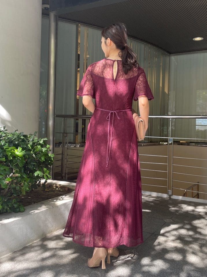 レッド系のドレス、ゴールド系のクラッチバッグ、ゴールド系のパンプスを着用したレディースの秋コーディネートの5枚目の写真