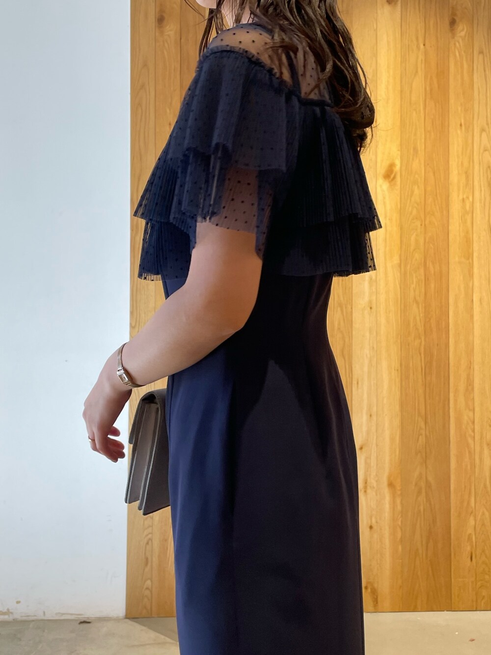 グレー系のパンプス、グレー系のクラッチバッグ、ブルー系のドレスを着用したレディースの冬コーディネートの8枚目の写真