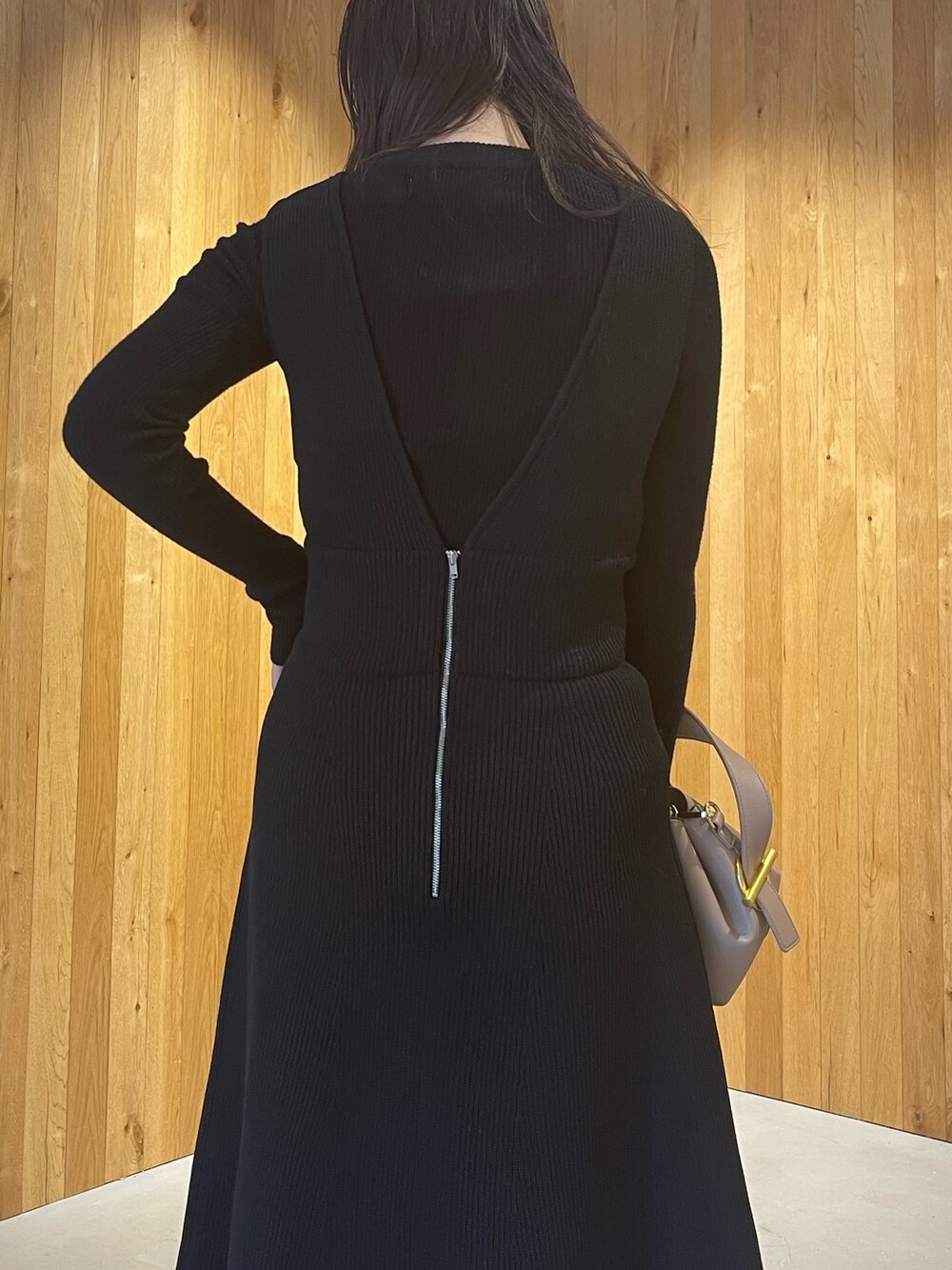 ベージュ系のハンドバッグ、グリーン系のブーツ、ブラック系のスカートを着用したレディースの秋コーディネートの7枚目の写真