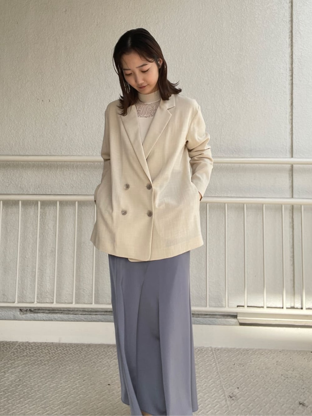 ホワイト系のニット/セーター、ベージュ系のブーツ、ブルー系のスカートを着用したレディースの春コーディネートの4枚目の写真