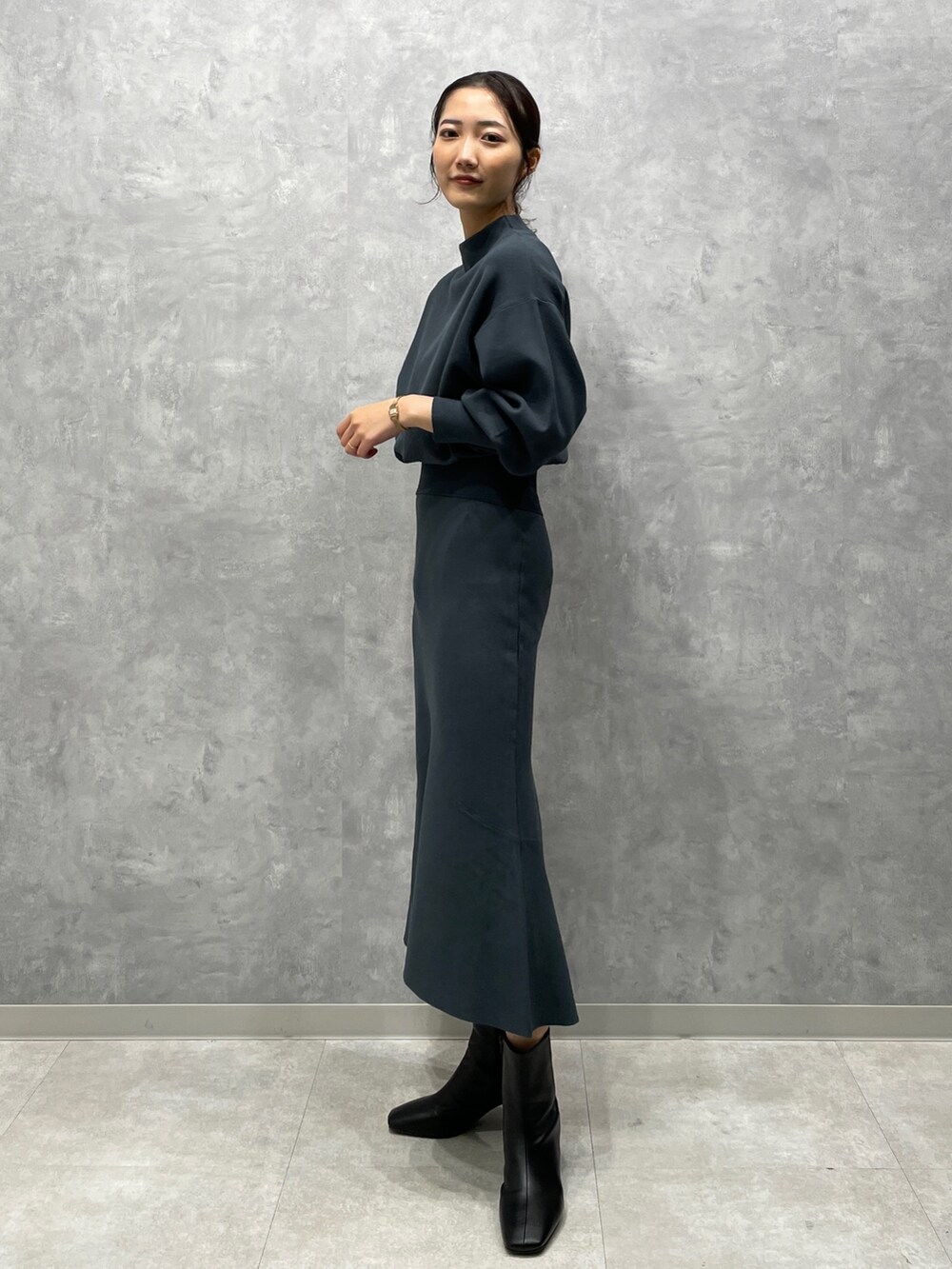 ホワイト系のカーディガン/ボレロ、グリーン系のニット/セーター、グリーン系のスカートを着用したレディースの冬コーディネートの7枚目の写真