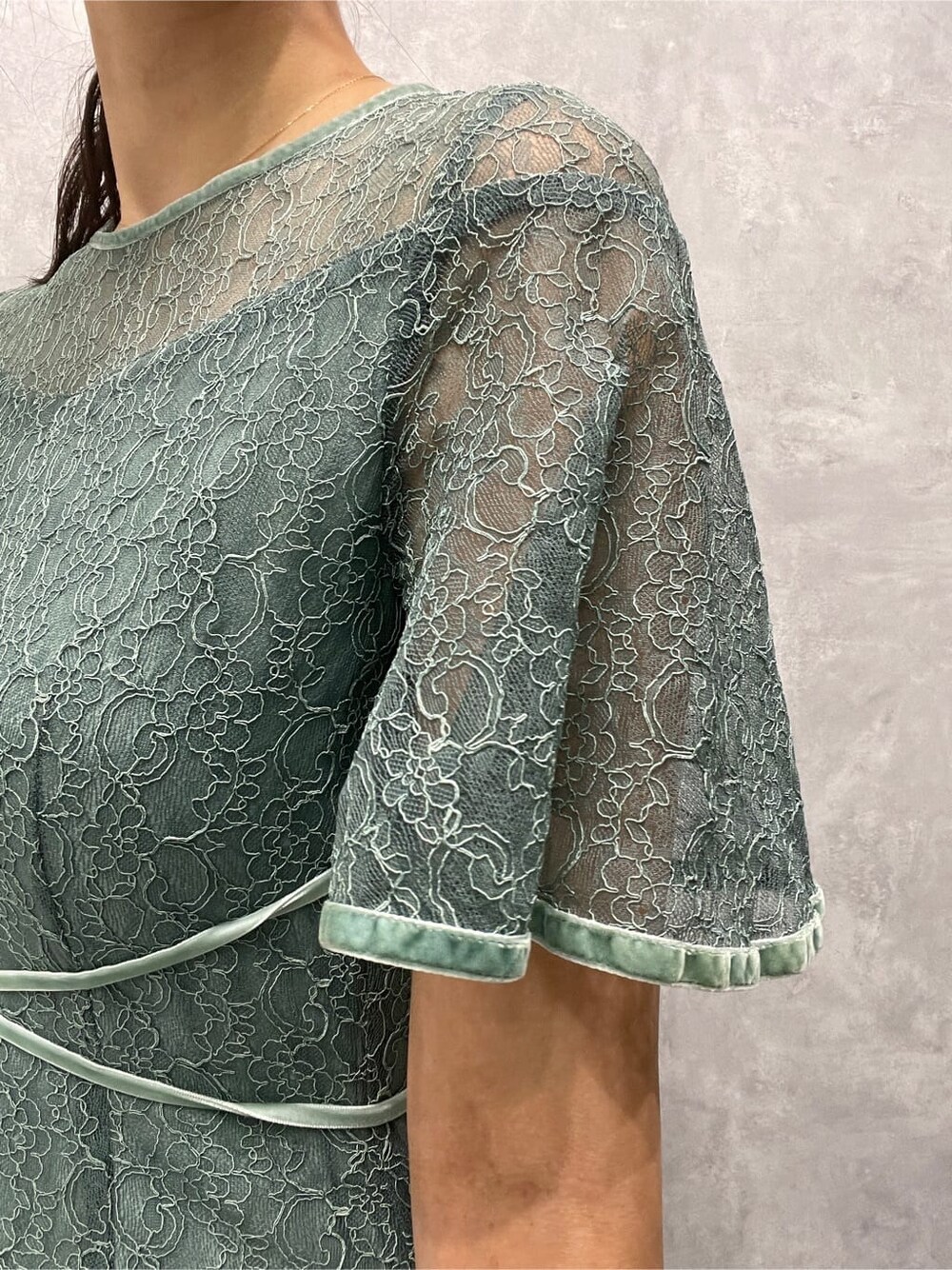 シルバー系のパンプス、シルバー系のクラッチバッグ、グリーン系のドレスを着用したレディースの夏コーディネートの8枚目の写真