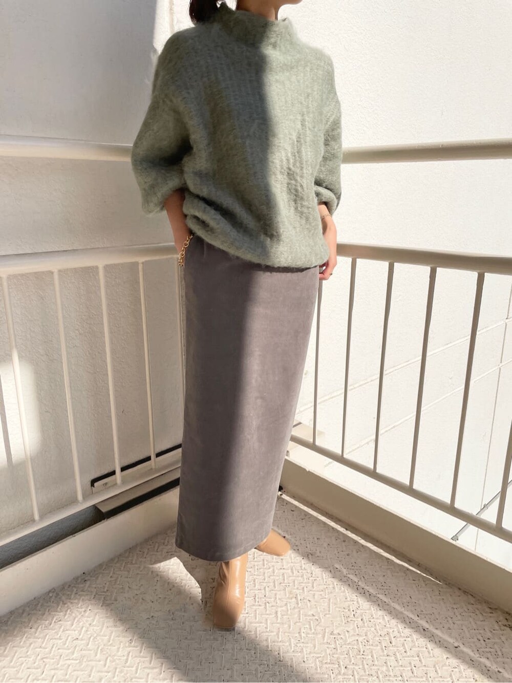 ベージュ系のその他シューズ、グリーン系のニット/セーター、グレー系のスカートを着用したレディースの秋コーディネートの4枚目の写真