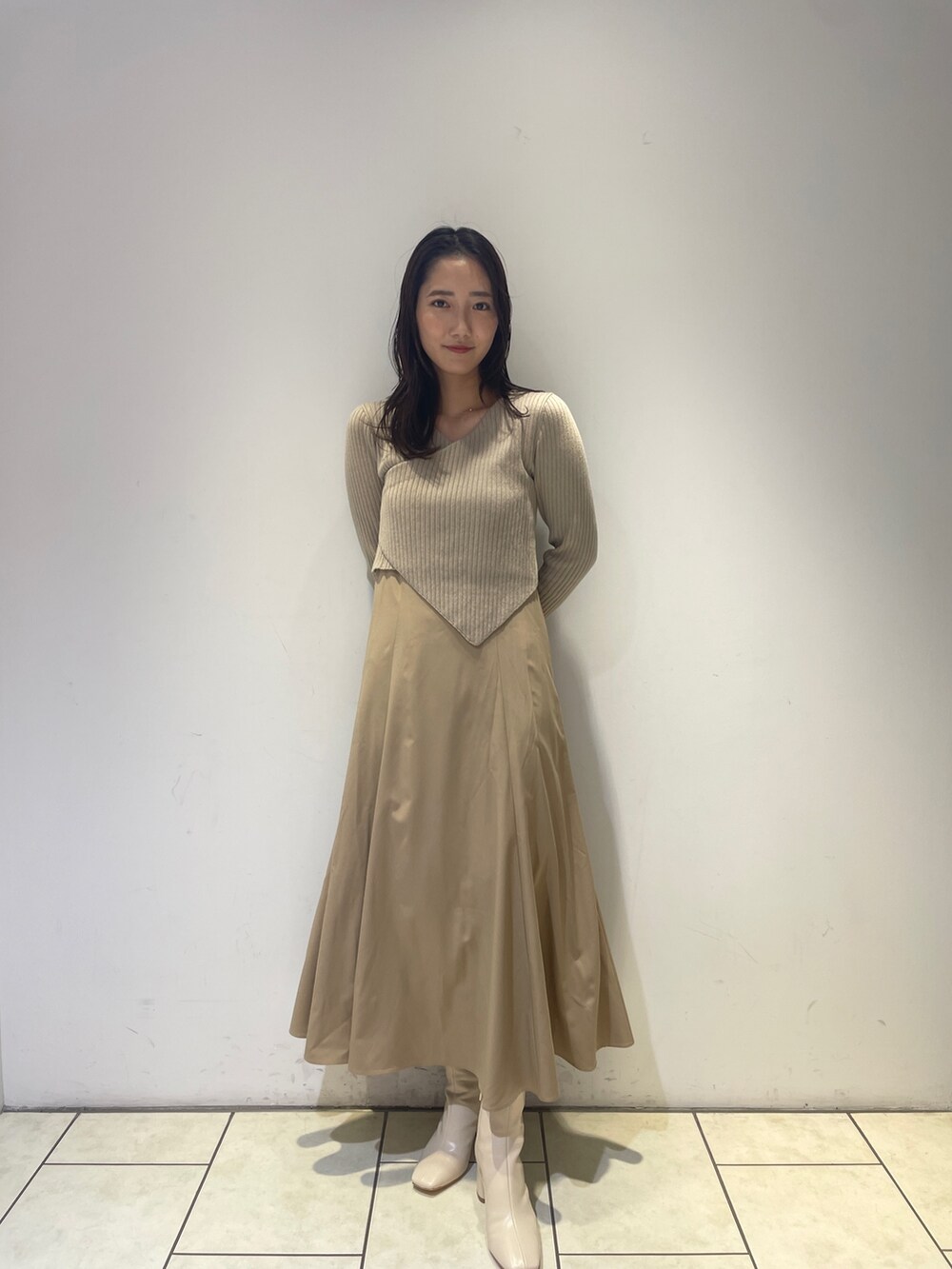 ベージュ系のワンピース、ホワイト系のブーツを着用したレディースの秋コーディネートの3枚目の写真