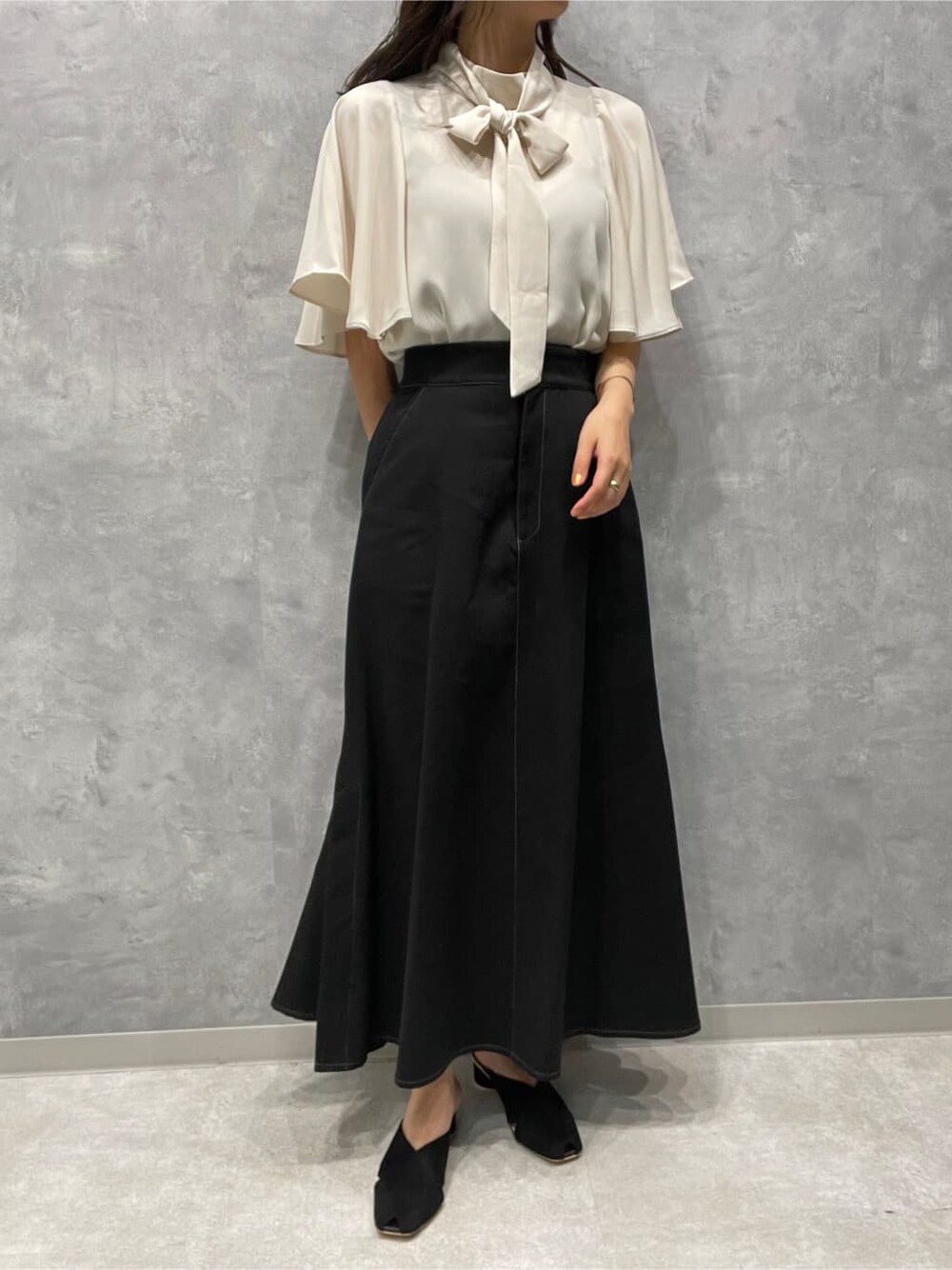 ブラック系のサンダル、ブラック系のスカート、ホワイト系のシャツ/ブラウスを着用したレディースの夏コーディネートの4枚目の写真