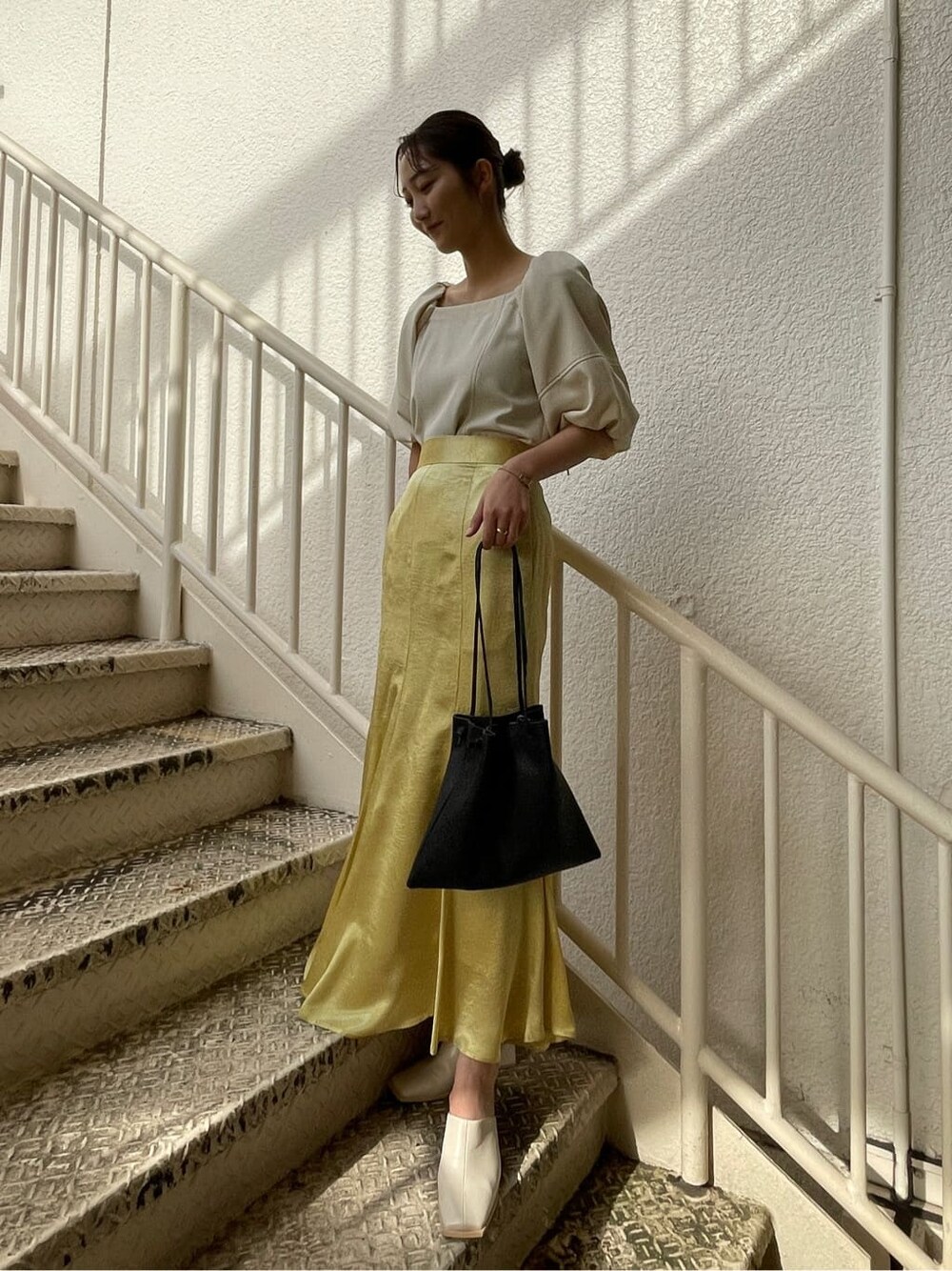 ホワイト系のシャツ/ブラウス、ホワイト系のテーラードジャケット、イエロー系のスカートを着用したレディースの冬コーディネートの4枚目の写真