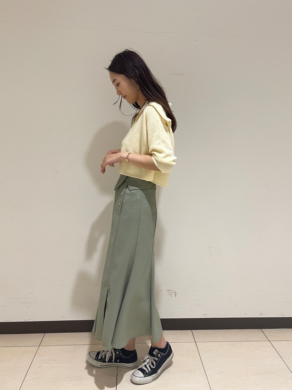 ホワイト系のカーディガン/ボレロ、グリーン系のスカートを着用したレディースの春コーディネートの4枚目の写真
