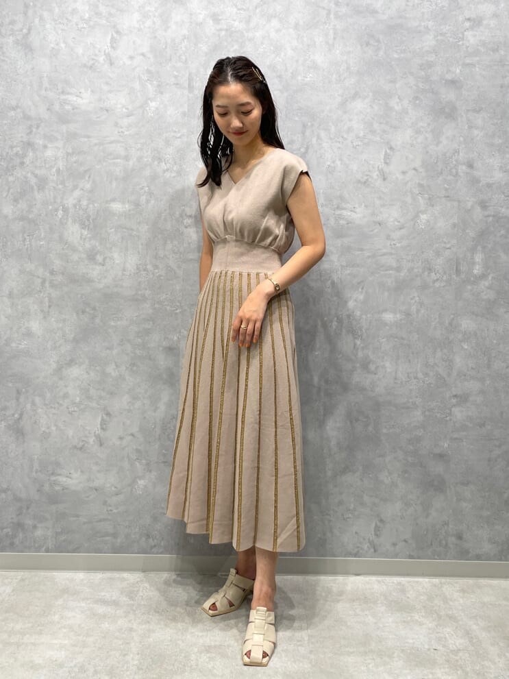 ホワイト系のサンダル、ベージュ系のワンピースを着用したレディースの夏コーディネートの2枚目の写真