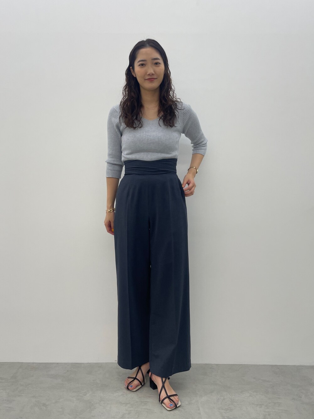 ブラック系のサンダル、ブルー系のスラックス、ブルー系のニット/セーターを着用したレディースの春コーディネートの2枚目の写真