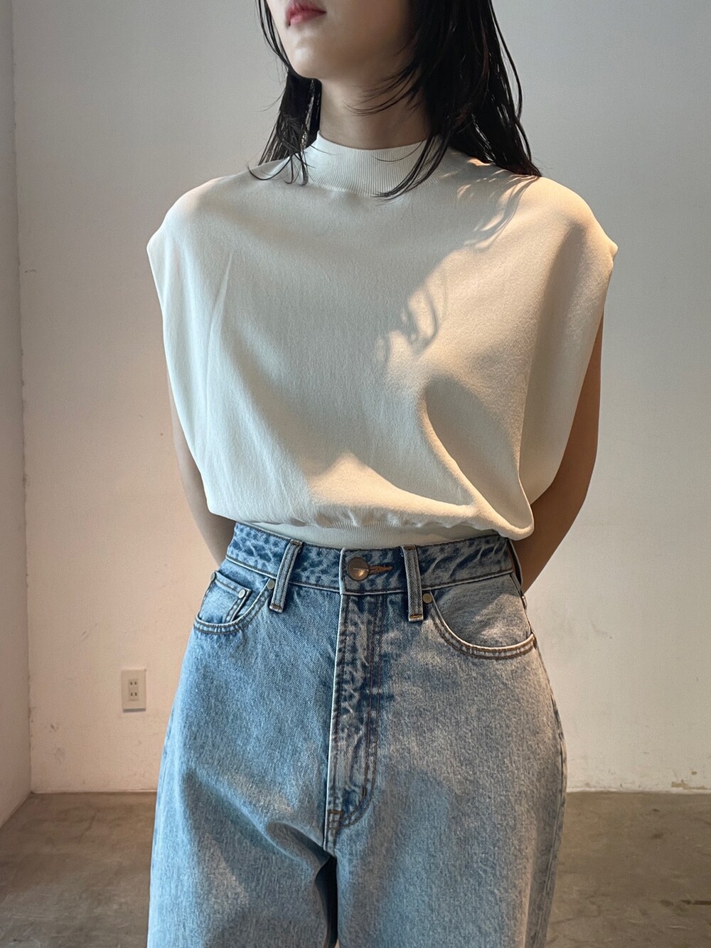 ブルー系のデニムパンツ、ホワイト系のニット/セーター、イエロー系のサンダルを着用したレディースの夏コーディネートの3枚目の写真