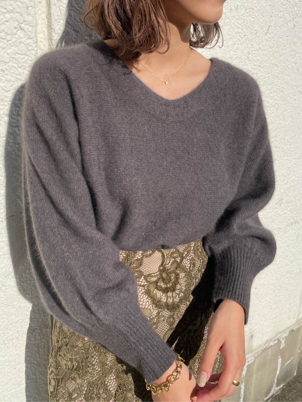 ベージュ系のその他シューズ、ベージュ系のスカート、グレー系のニット/セーターを着用したレディースの冬コーディネートの3枚目の写真