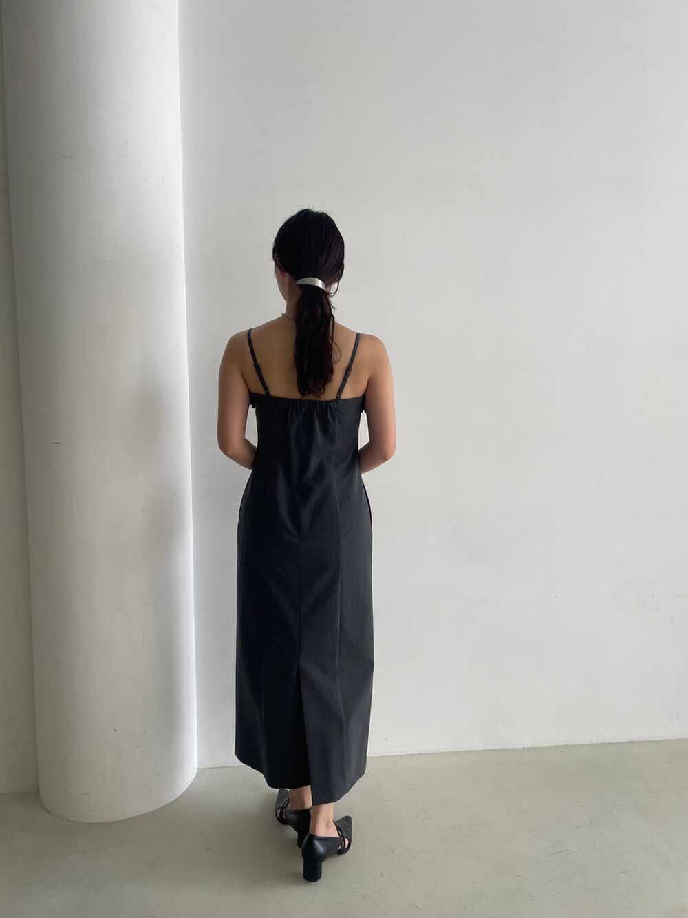 グレー系のドレス、ブラック系のパンプス、グレー系のチェスターコートを着用したレディースの秋コーディネートの8枚目の写真