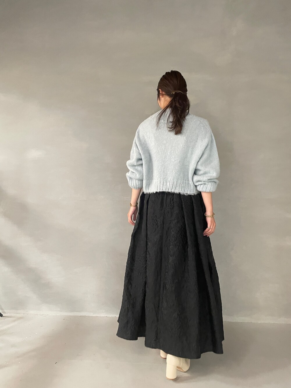 ホワイト系のブーツ、ブラック系のスカート、グリーン系のニット/セーターを着用したレディースの夏コーディネートの7枚目の写真