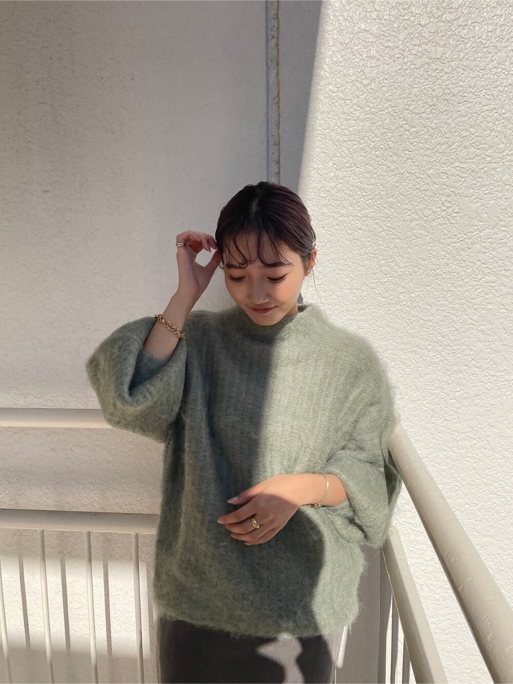 ベージュ系のその他シューズ、グリーン系のニット/セーター、グレー系のスカートを着用したレディースの秋コーディネートの6枚目の写真