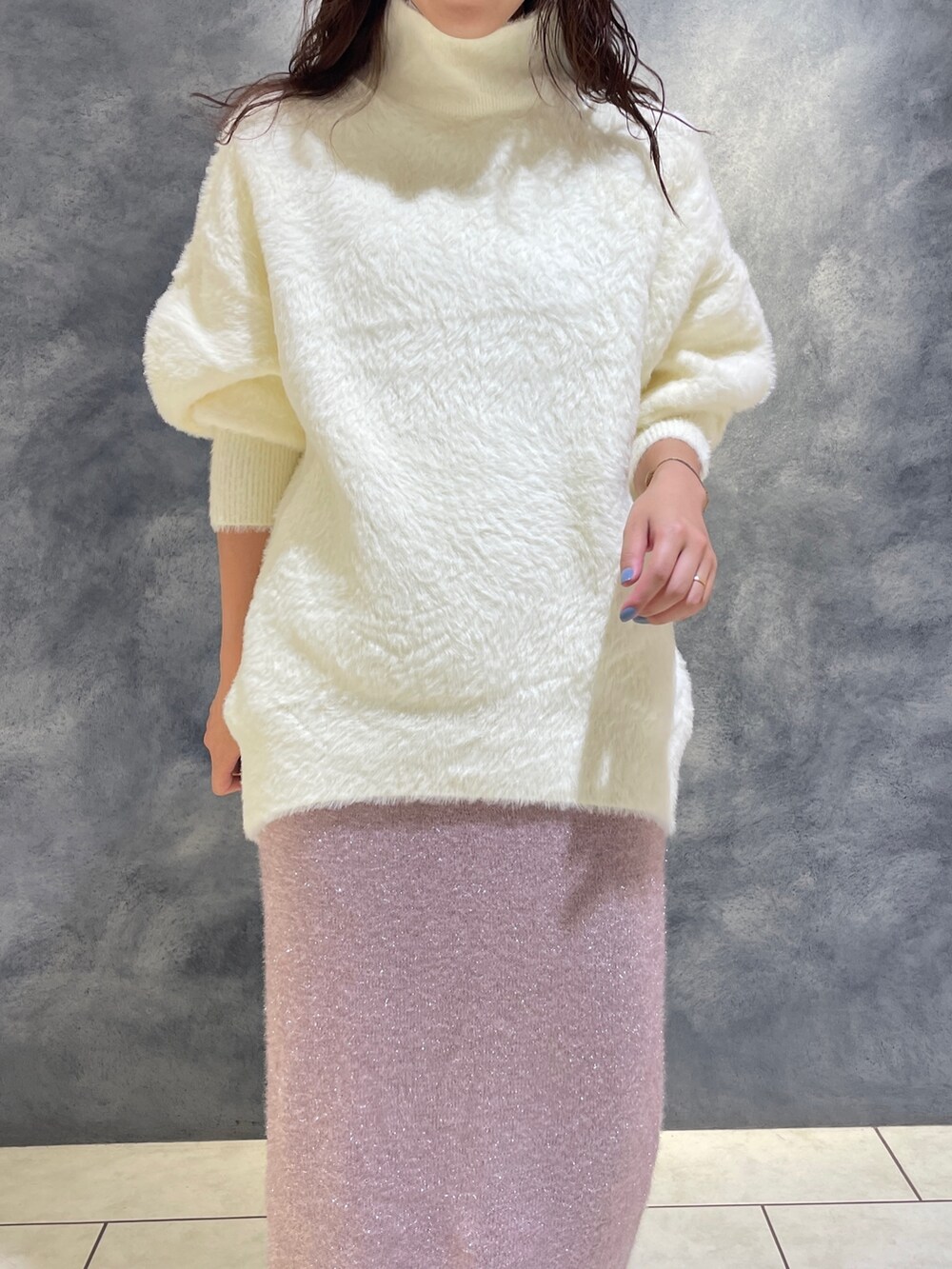 ホワイト系のニット/セーター、ピンク系のスカート、ブラック系のブーツを着用したレディースの秋コーディネートの7枚目の写真