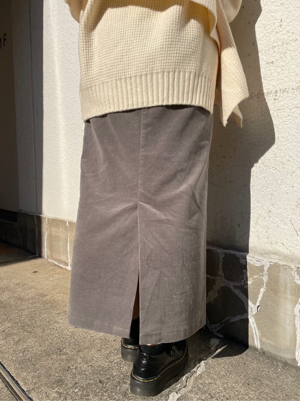 グレー系のスカート、ホワイト系のニット/セーターを着用したレディースの冬コーディネートの5枚目の写真