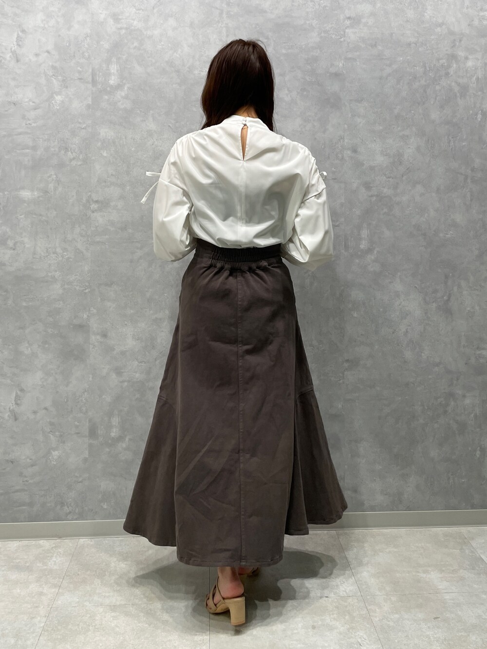 ベージュ系のサンダル、グレー系のスカート、グレー系のテーラードジャケットを着用したレディースの春コーディネートの9枚目の写真