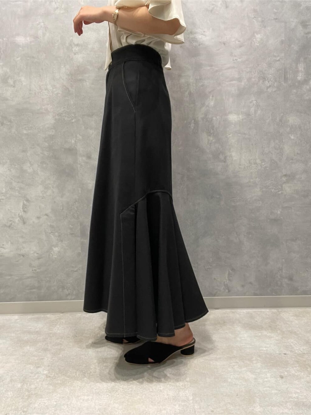 ブラック系のサンダル、ブラック系のスカート、ホワイト系のシャツ/ブラウスを着用したレディースの夏コーディネートの8枚目の写真