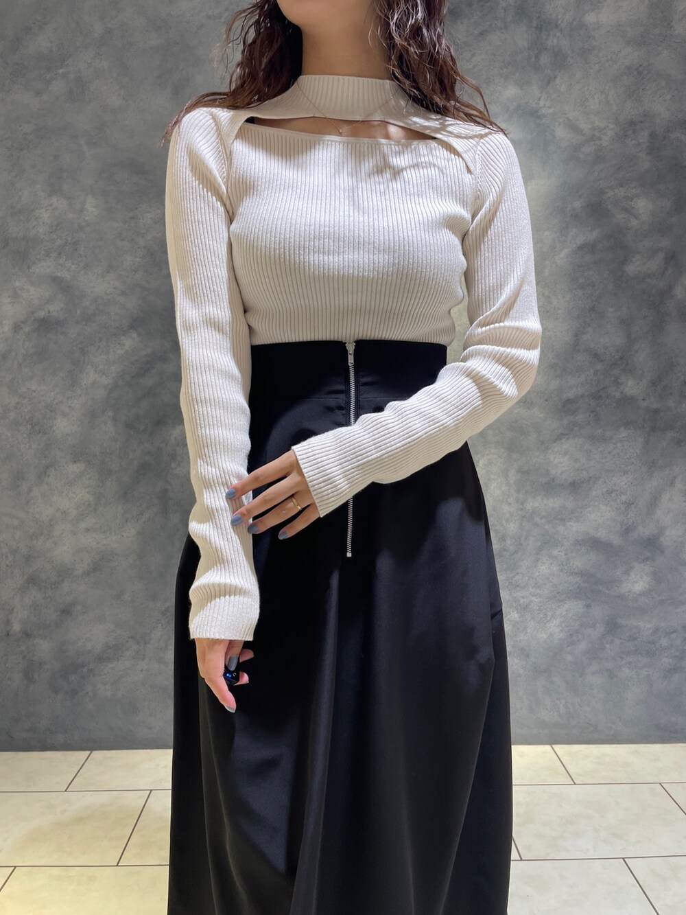 ブラック系のスカート、ホワイト系のニット/セーター、ブラック系のブーツを着用したレディースの秋コーディネートの7枚目の写真