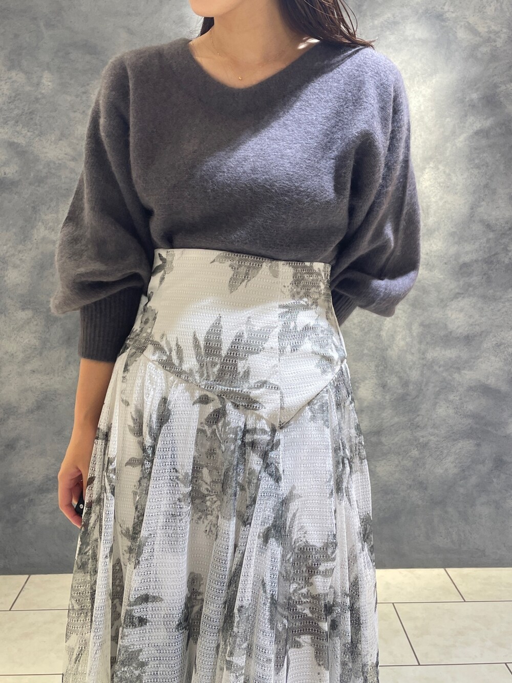 ブラック系のスカート、ブラック系のブーツ、グレー系のニット/セーターを着用したレディースの秋コーディネートの8枚目の写真