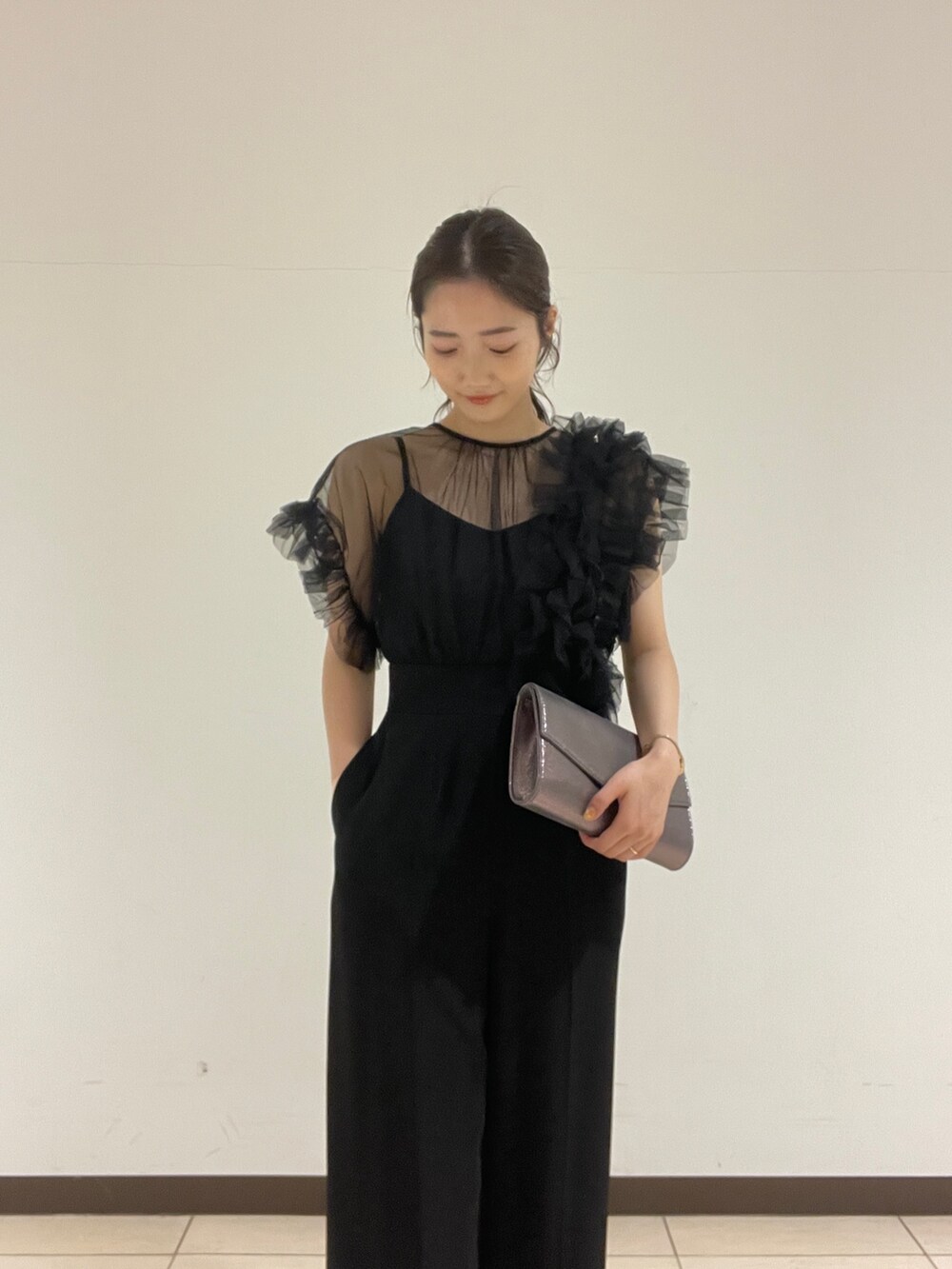 ブラック系のパンツドレス、シルバー系のクラッチバッグ、シルバー系のパンプスを着用したレディースの春コーディネートの10枚目の写真
